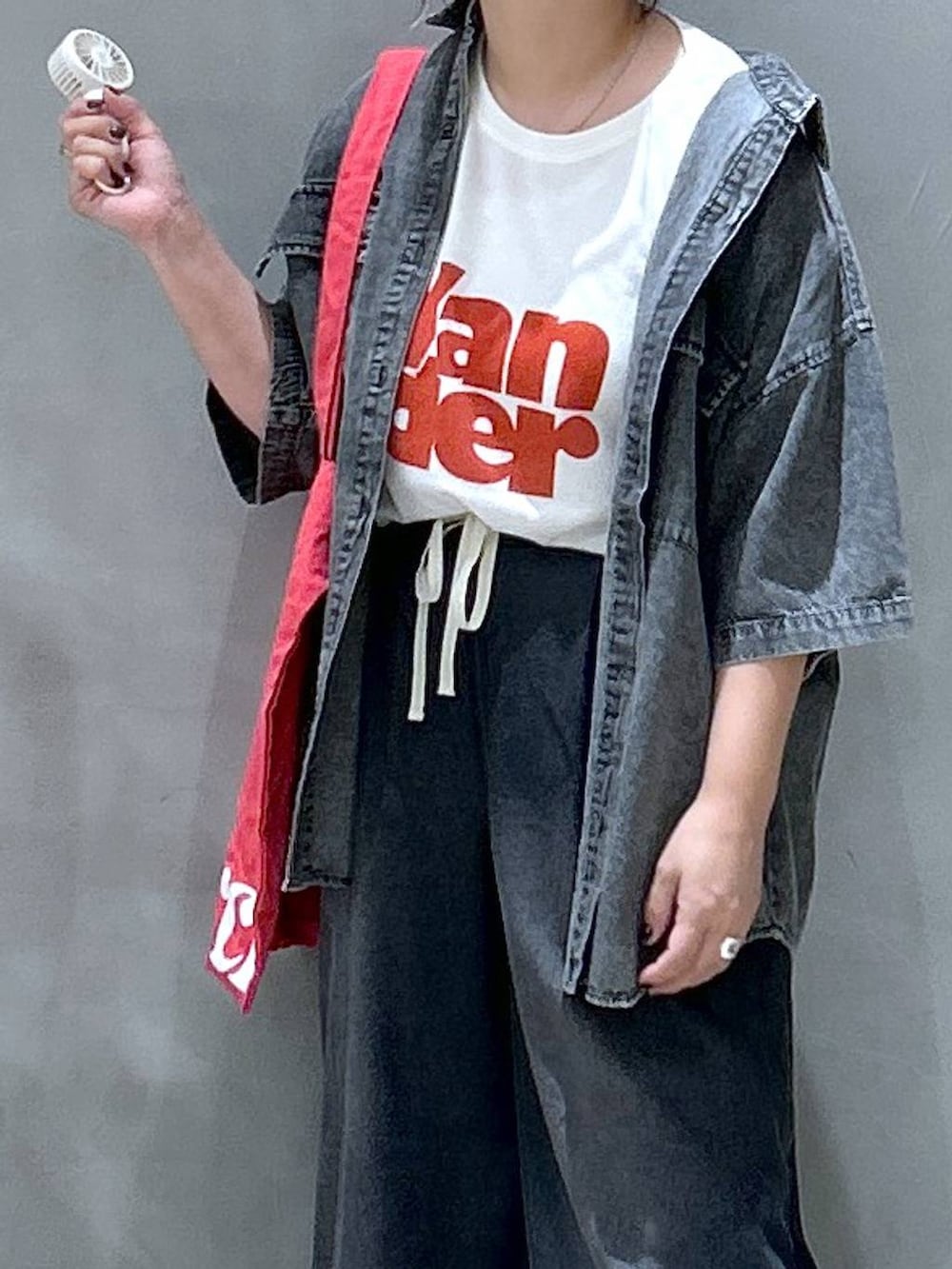 ブラック系のシャツ/ブラウス、レッド系のトートバッグ、ブラック系のデニムパンツを着用したレディースの夏コーディネートの8枚目の写真