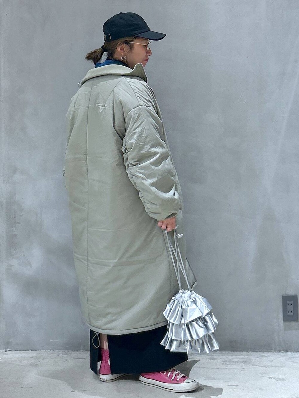 グリーン系のミリタリージャケット、ブラック系のスカート、シルバー系のショルダーバッグを着用したレディースの冬コーディネートの2枚目の写真