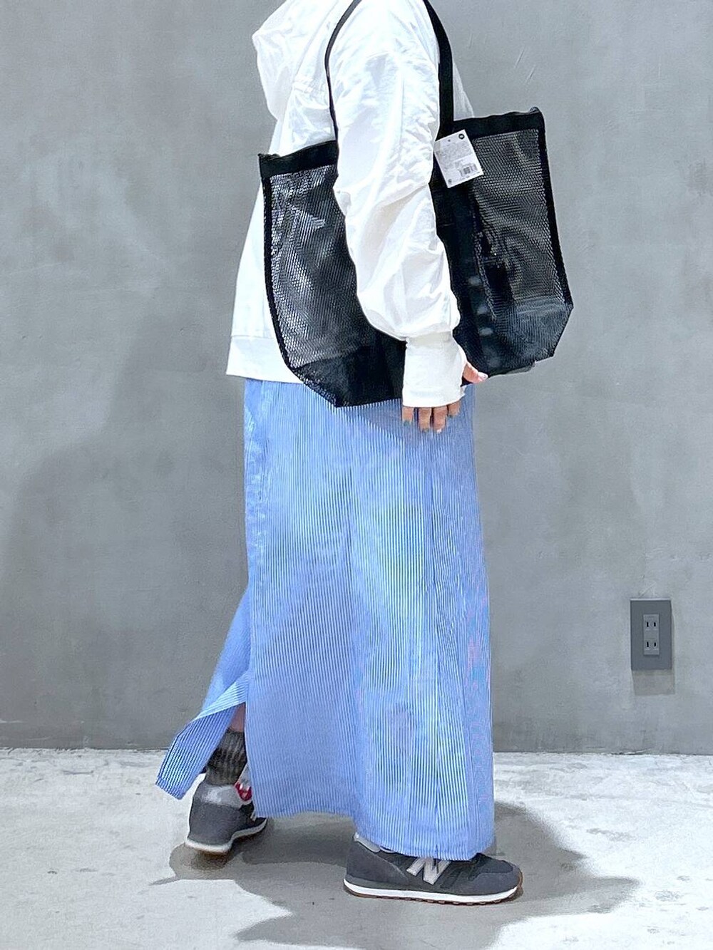 グレー系のスニーカー、グレー系のTシャツ/カットソー、ブルー系のワンピースを着用したレディースの春コーディネートの5枚目の写真