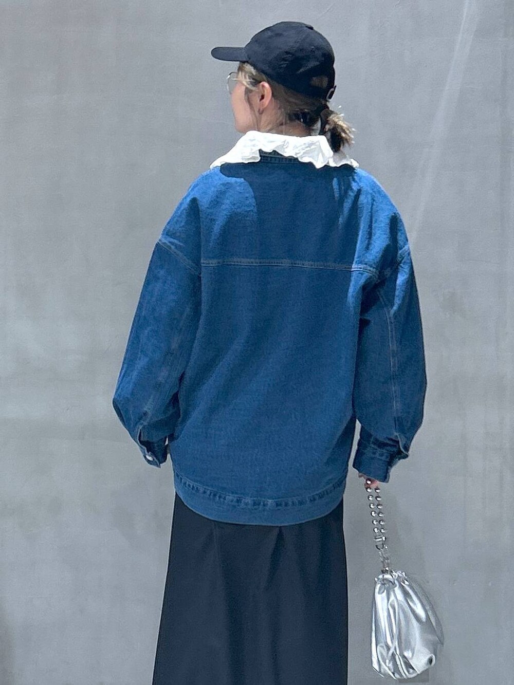 シルバー系のショルダーバッグ、ブルー系のデニムジャケット、ホワイト系のシャツ/ブラウスを着用したレディースの冬コーディネートの6枚目の写真