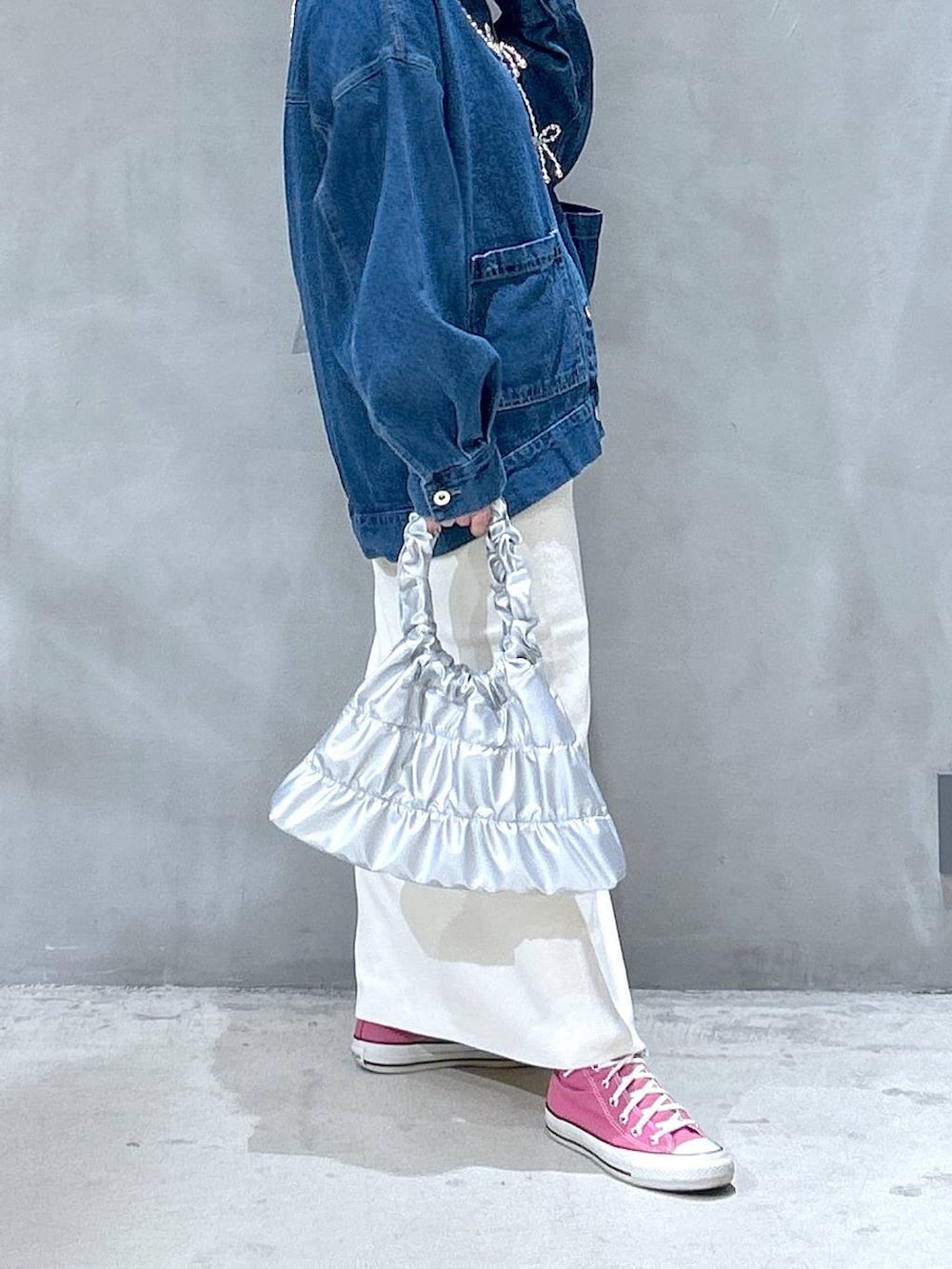 ベージュ系のスカート、シルバー系のショルダーバッグ、ブルー系のデニムジャケットを着用したレディースの冬コーディネートの4枚目の写真