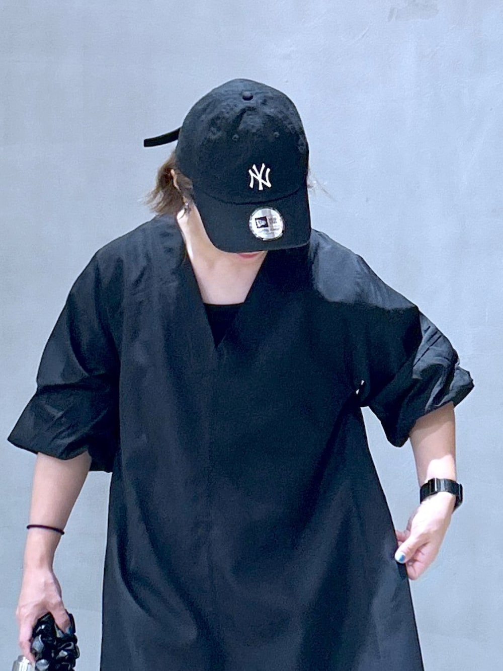 ブラック系のワンピース、グレー系のスニーカー、ホワイト系のショルダーバッグを着用したレディースの夏コーディネートの4枚目の写真