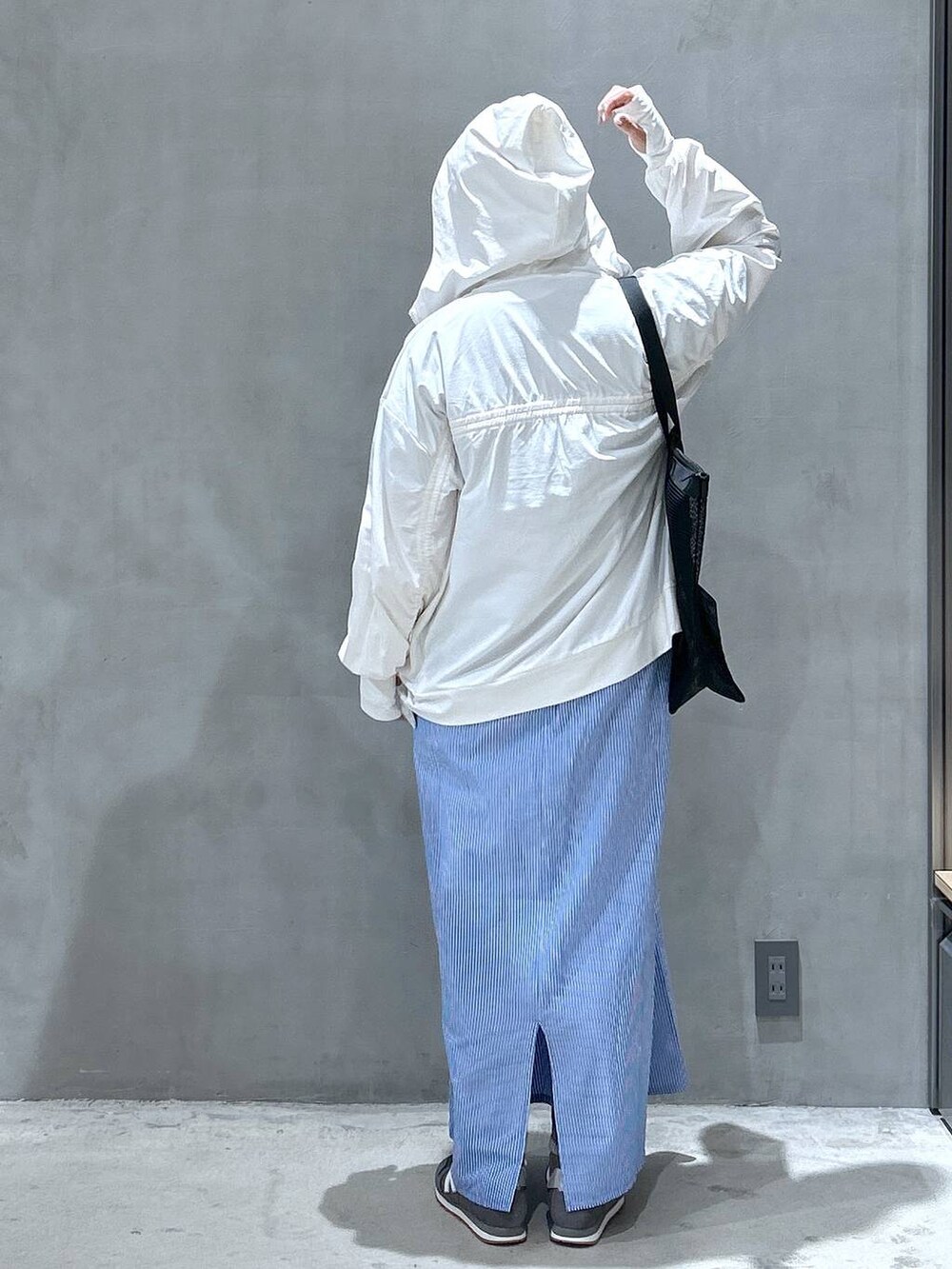 グレー系のスニーカー、グレー系のTシャツ/カットソー、ブルー系のワンピースを着用したレディースの春コーディネートの2枚目の写真