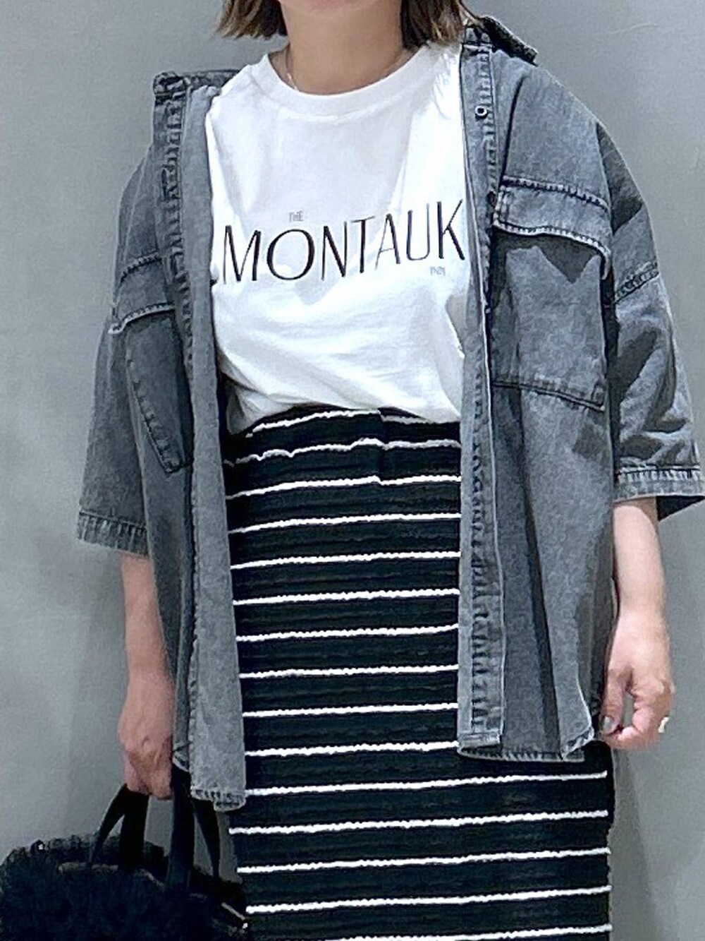 ブラック系のスニーカー、ブラック系のシャツ/ブラウス、ベージュ系のショルダーバッグを着用したレディースの春コーディネートの4枚目の写真