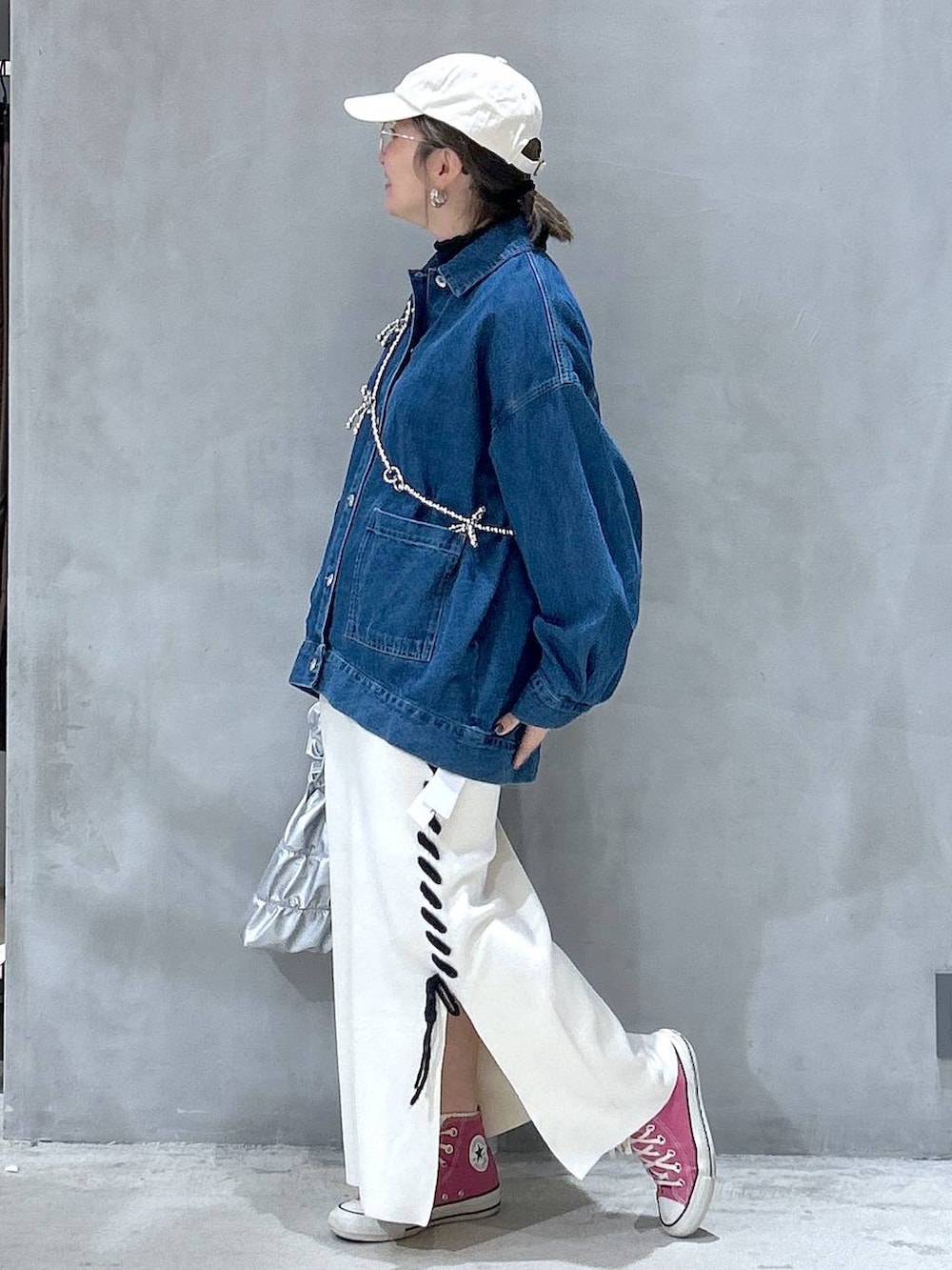 ベージュ系のスカート、シルバー系のショルダーバッグ、ブルー系のデニムジャケットを着用したレディースの冬コーディネートの2枚目の写真