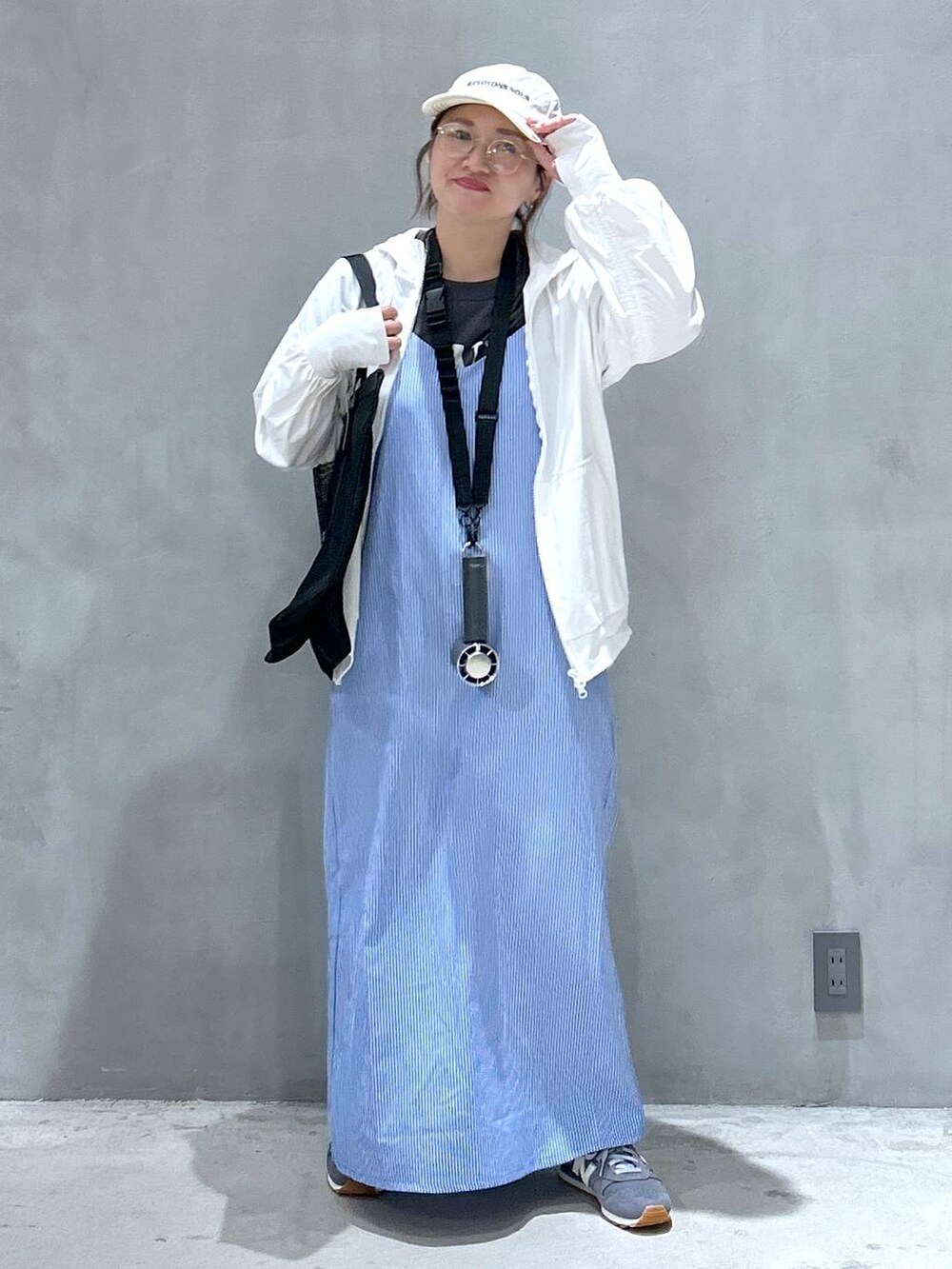 グレー系のスニーカー、グレー系のTシャツ/カットソー、ブルー系のワンピースを着用したレディースの春コーディネートの3枚目の写真