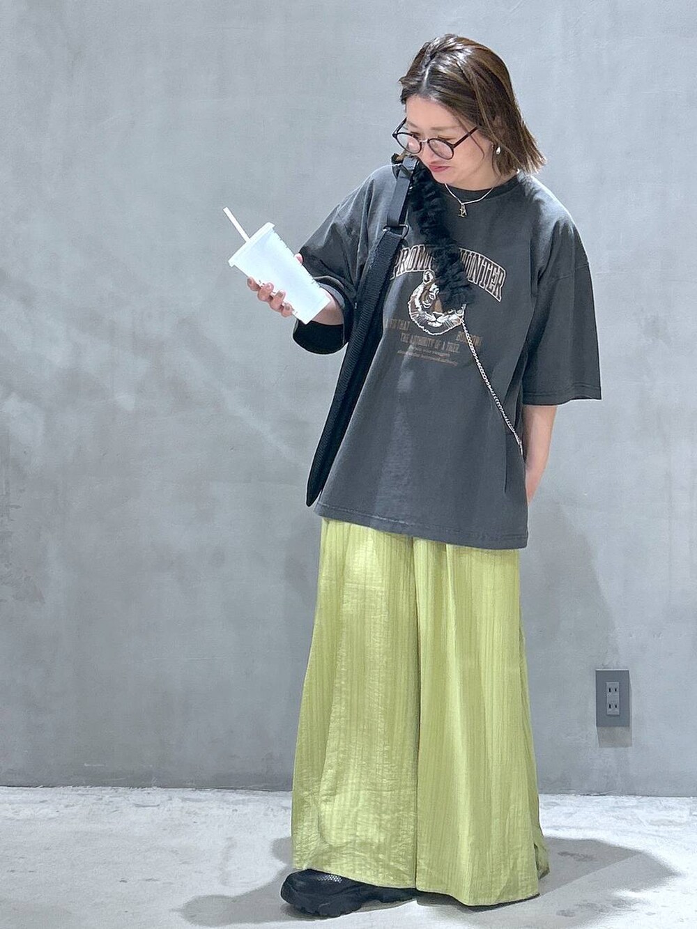 ブラック系のスニーカー、グリーン系のその他パンツ、グレー系のTシャツ/カットソーを着用したレディースの春コーディネートの5枚目の写真