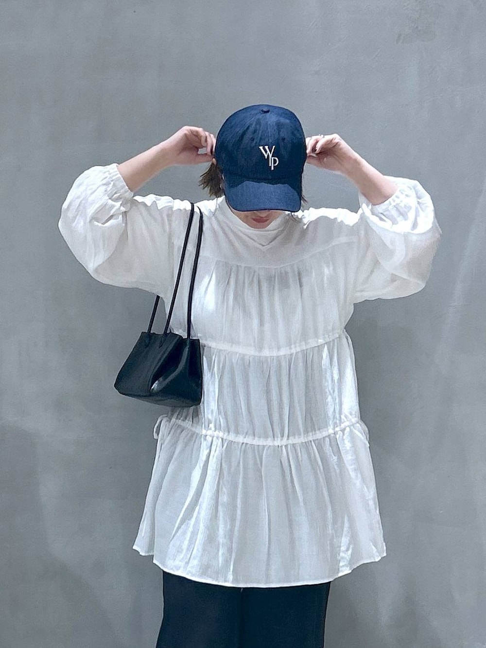 ブラック系のトートバッグ、ブラック系のスニーカー、ブラック系のその他パンツを着用したレディースの春コーディネートの4枚目の写真