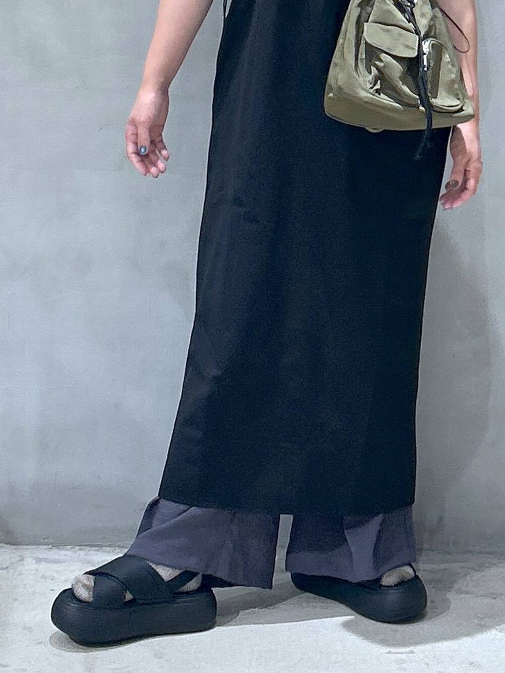 ブラック系のサンダル、グリーン系のショルダーバッグ、ブラック系のワンピースを着用したレディースの夏コーディネートの4枚目の写真