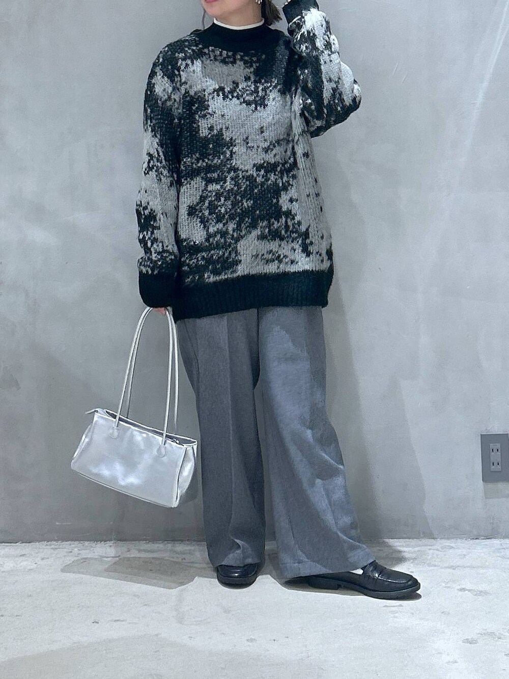 ブラック系のニット/セーター、ブラック系のローファー、シルバー系のトートバッグを着用したレディースの秋コーディネートの4枚目の写真