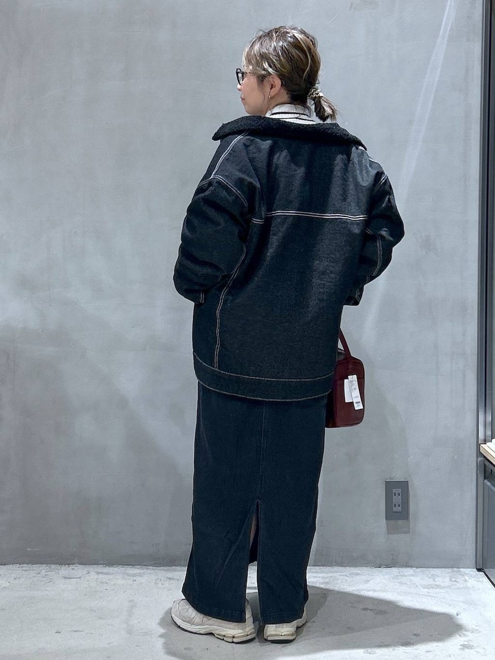 グレー系のジャンパースカート、レッド系のショルダーバッグ、その他のニット/セーターを着用したレディースの冬コーディネートの2枚目の写真