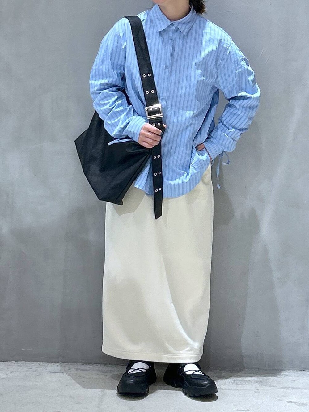 ホワイト系のスカート、ブラック系のスニーカー、ブラック系のショルダーバッグを着用したレディースの春コーディネートの3枚目の写真