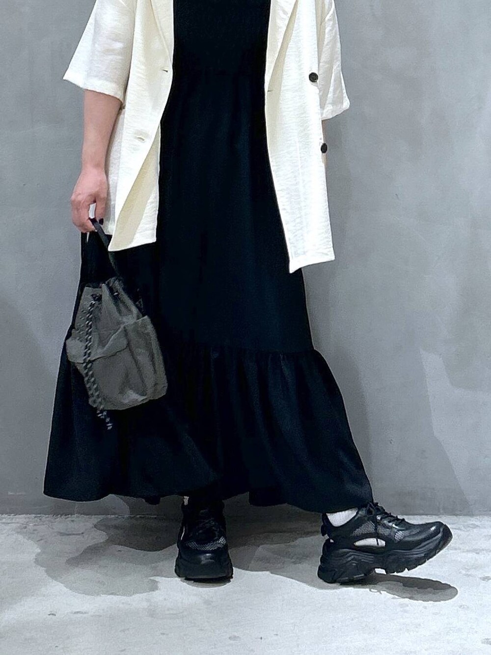 ブラック系のスニーカー、グリーン系のショルダーバッグ、ホワイト系のTシャツ/カットソーを着用したレディースの春コーディネートの4枚目の写真