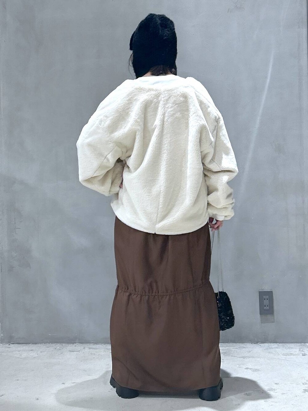 ベージュ系のブルゾン、ブラック系のブーツ、ブラウン系のワンピースを着用したレディースの秋コーディネートの2枚目の写真