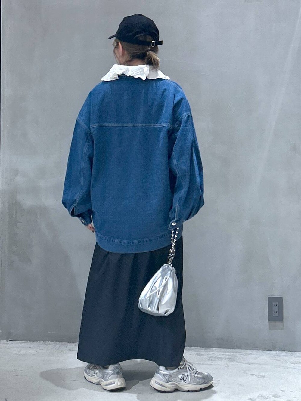 シルバー系のショルダーバッグ、ブルー系のデニムジャケット、ホワイト系のシャツ/ブラウスを着用したレディースの冬コーディネートの2枚目の写真