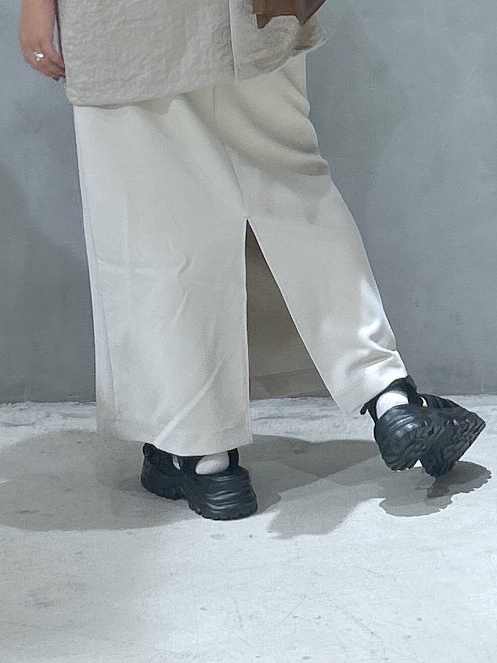 ブラック系のトートバッグ、ベージュ系のスカート、ベージュ系のテーラードジャケットを着用したレディースの夏コーディネートの4枚目の写真