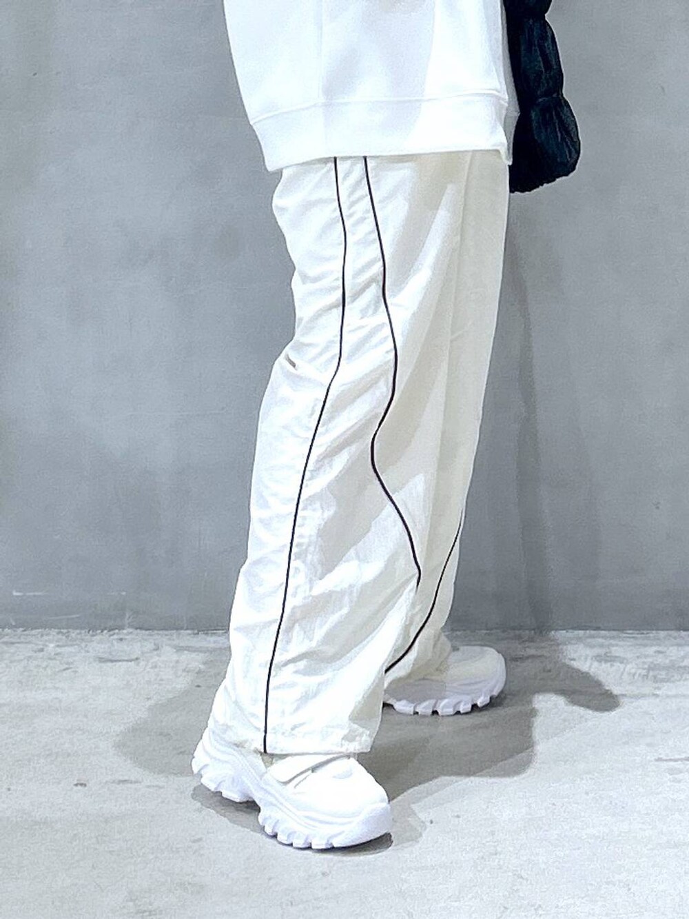 ホワイト系のスニーカー、ブラック系のショルダーバッグ、ベージュ系のその他パンツを着用したレディースの秋コーディネートの4枚目の写真