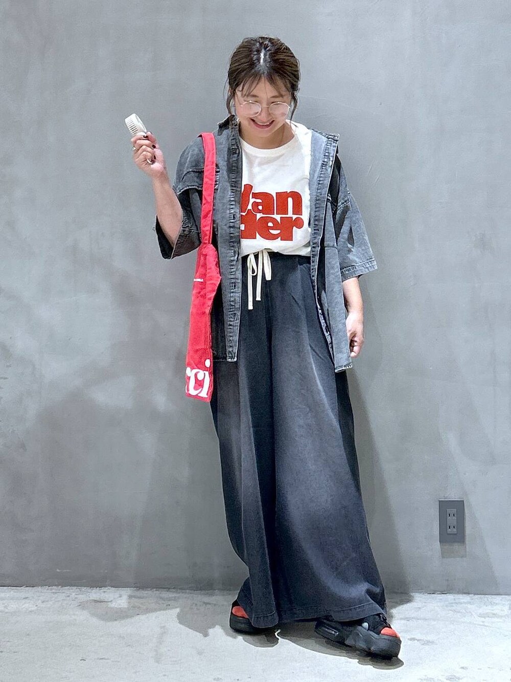 ブラック系のシャツ/ブラウス、レッド系のトートバッグ、ブラック系のデニムパンツを着用したレディースの夏コーディネートの7枚目の写真