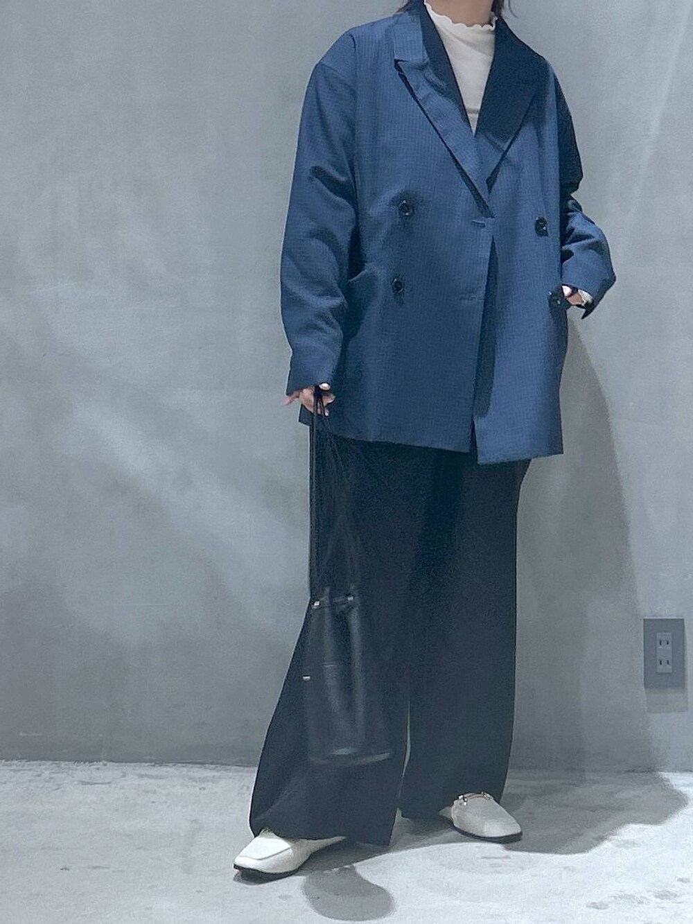 ベージュ系のTシャツ/カットソー、ブラック系のハンドバッグ、ベージュ系のローファーを着用したレディースの冬コーディネートの5枚目の写真