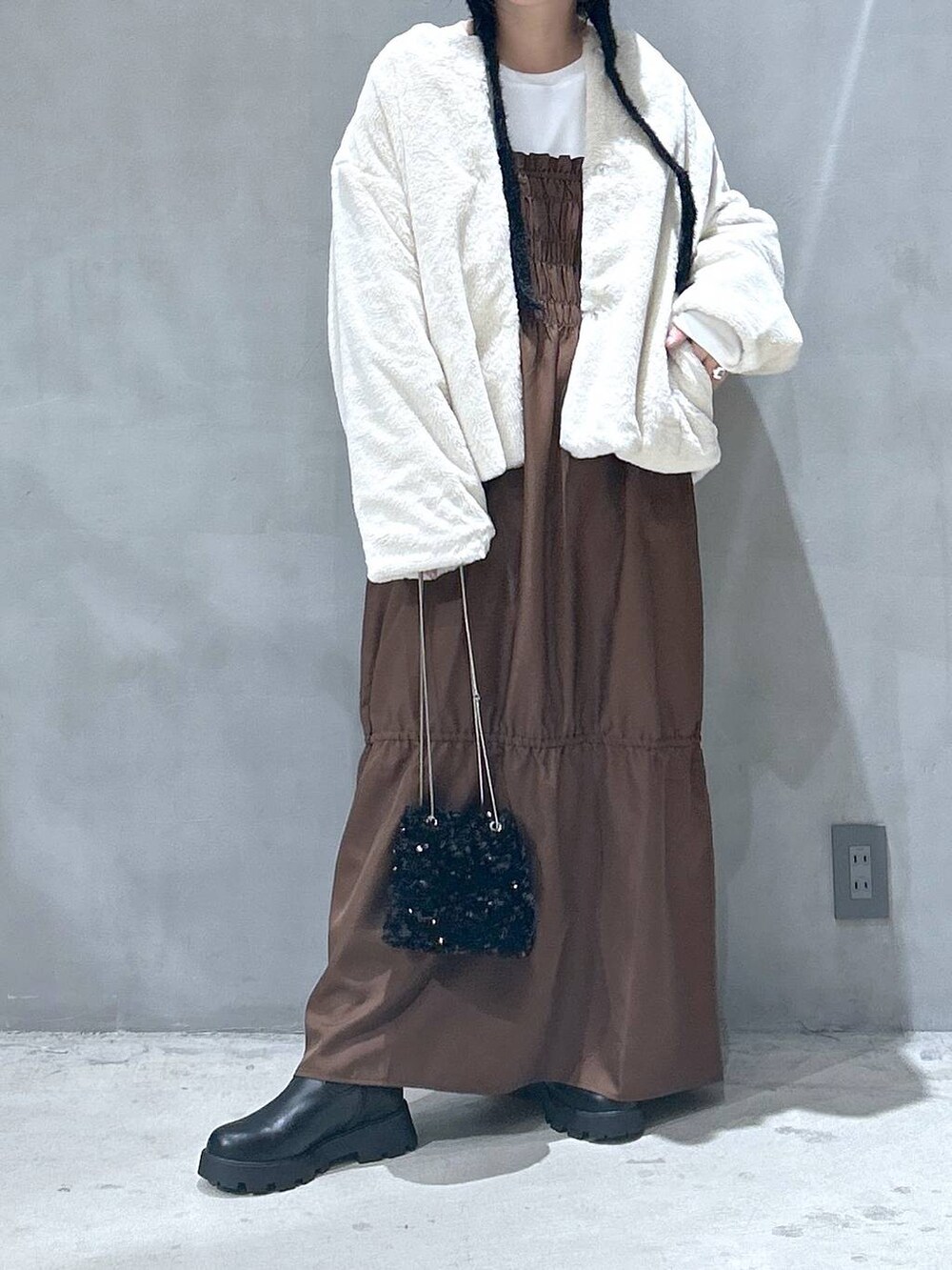 ベージュ系のブルゾン、ブラック系のブーツ、ブラウン系のワンピースを着用したレディースの秋コーディネートの3枚目の写真