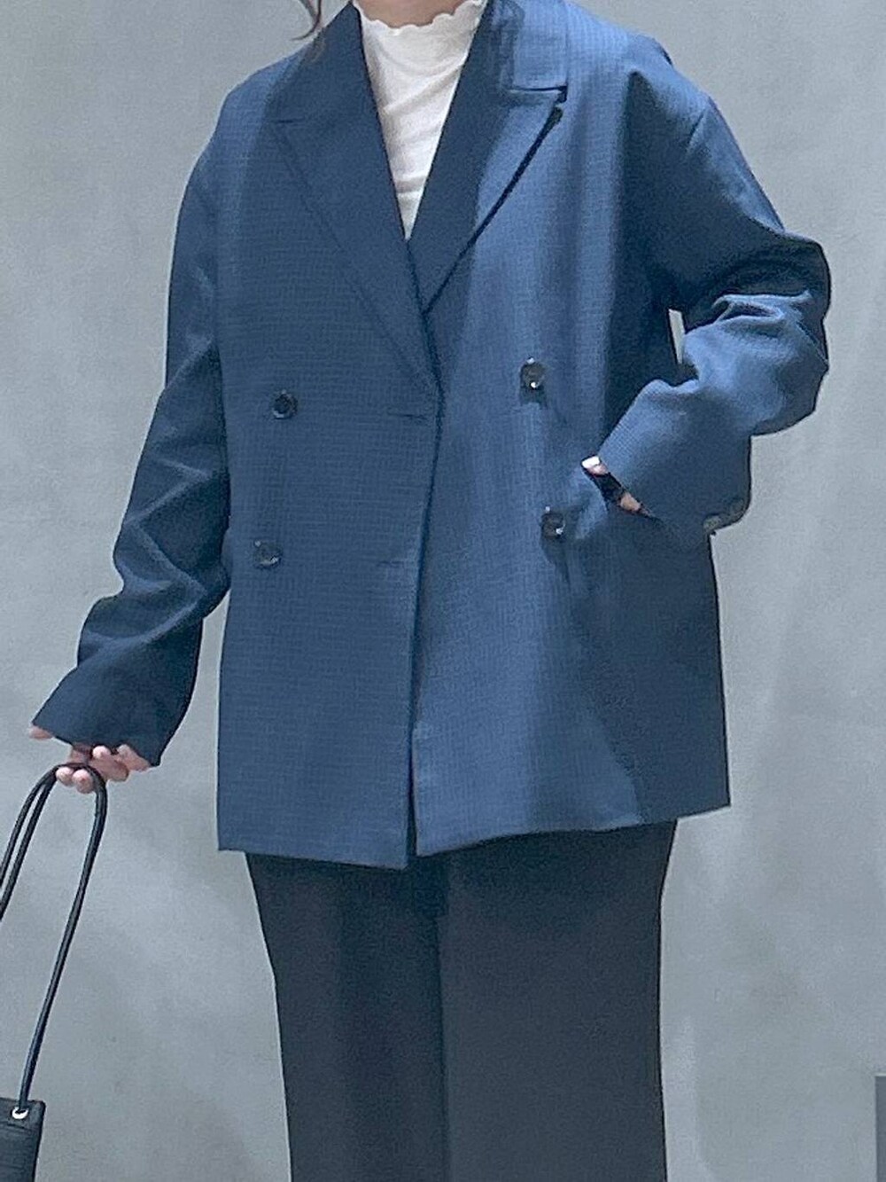 ベージュ系のTシャツ/カットソー、ブラック系のハンドバッグ、ベージュ系のローファーを着用したレディースの冬コーディネートの3枚目の写真