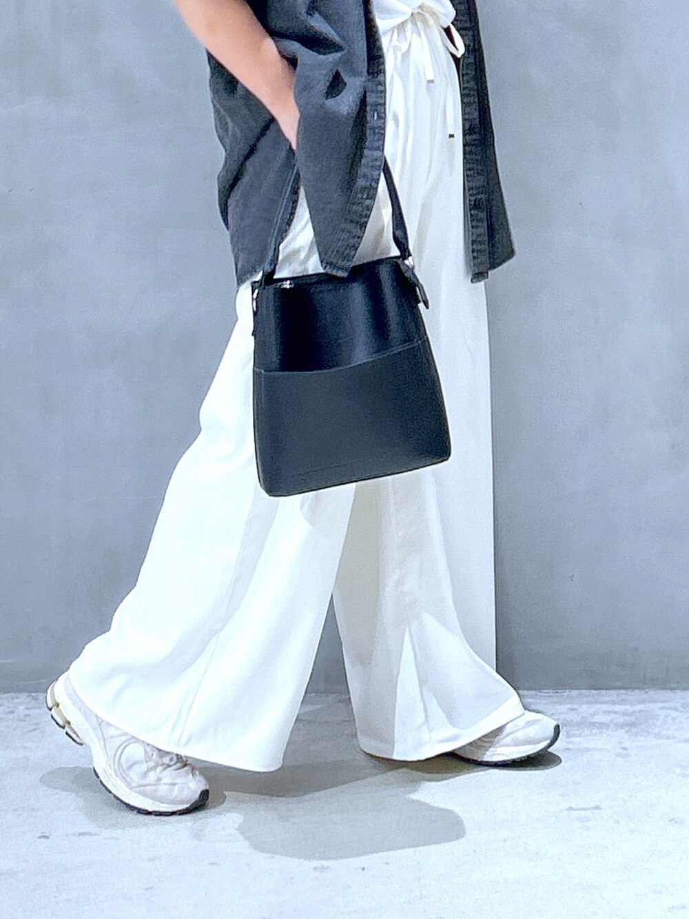 ブラック系のハンドバッグ、ホワイト系のその他パンツ、ブラック系のシャツ/ブラウスを着用したレディースの夏コーディネートの3枚目の写真