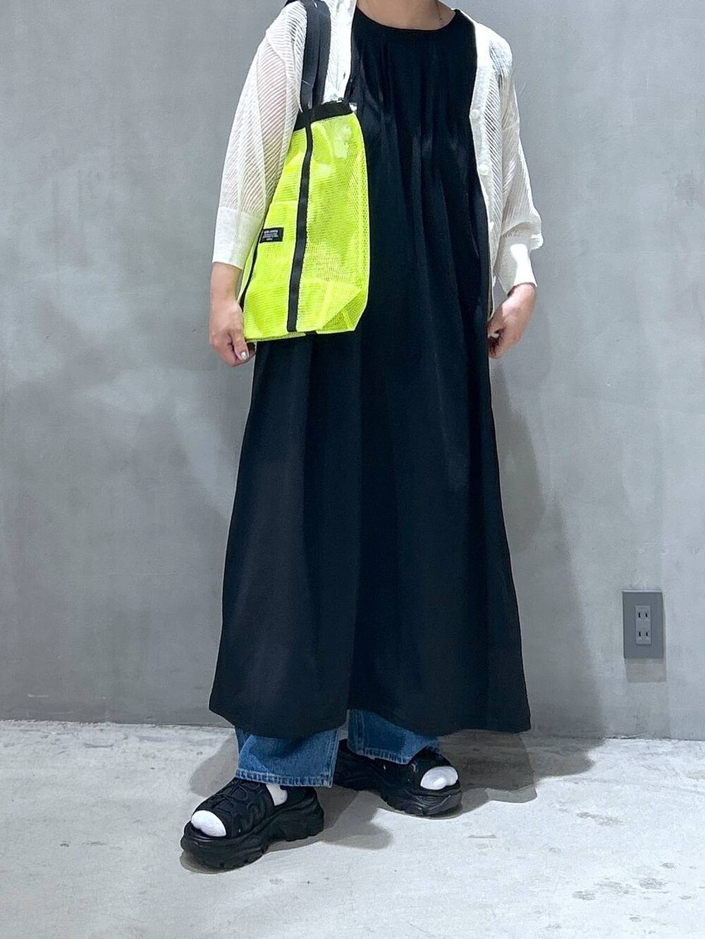 ブルー系のデニムパンツ、ブラック系のスニーカー、ホワイト系のカーディガン/ボレロを着用したレディースの春コーディネートの4枚目の写真