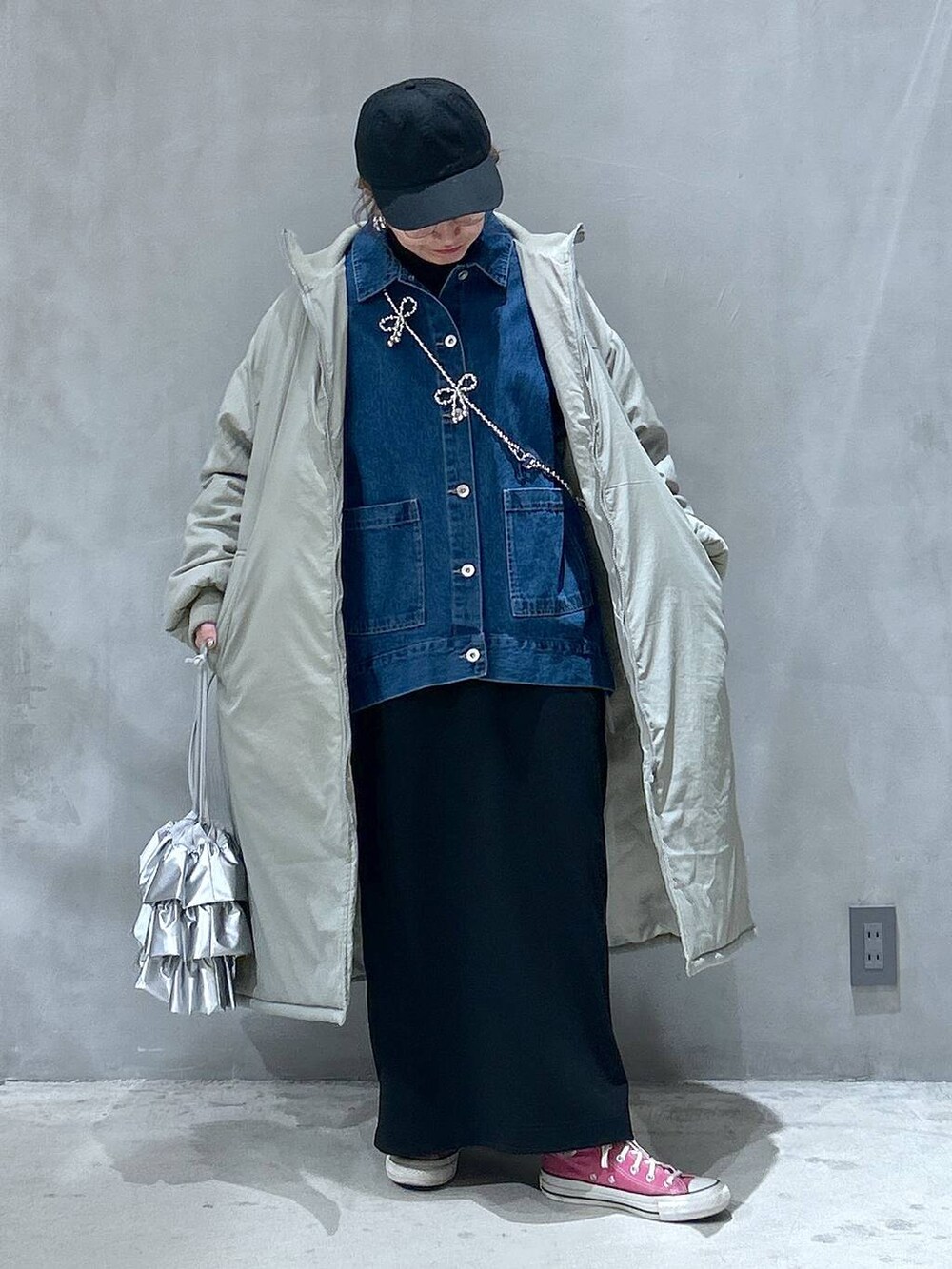 グリーン系のミリタリージャケット、ブラック系のスカート、シルバー系のショルダーバッグを着用したレディースの冬コーディネートの3枚目の写真