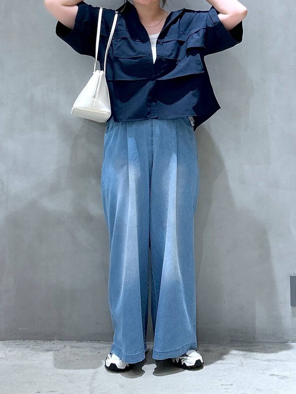 ホワイト系のスニーカー、ホワイト系のボストンバッグ、ブルー系のシャツ/ブラウスを着用したレディースの夏コーディネートの5枚目の写真