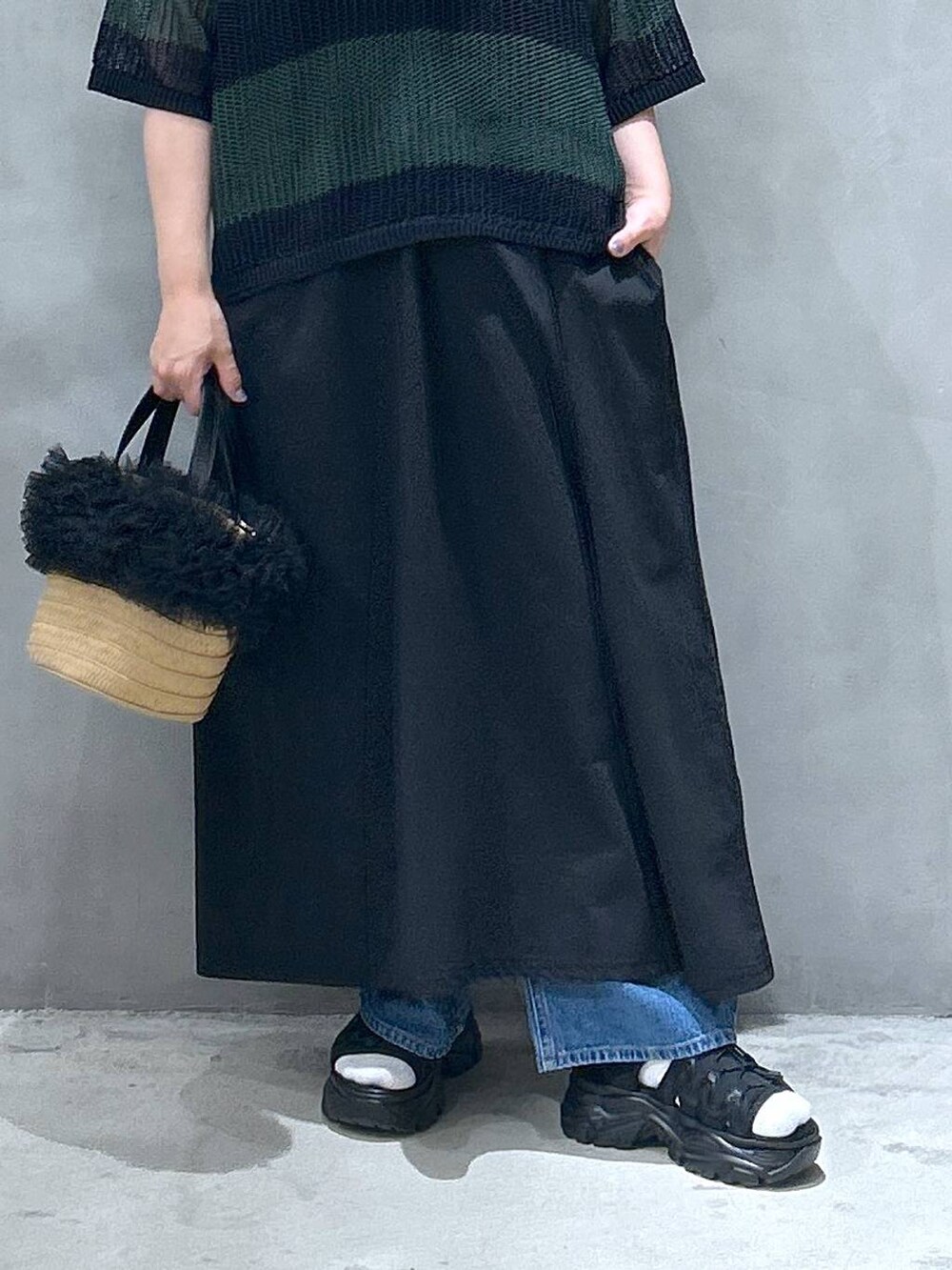 ブルー系のデニムパンツ、ベージュ系のショルダーバッグ、ブラック系のスニーカーを着用したレディースの春コーディネートの6枚目の写真