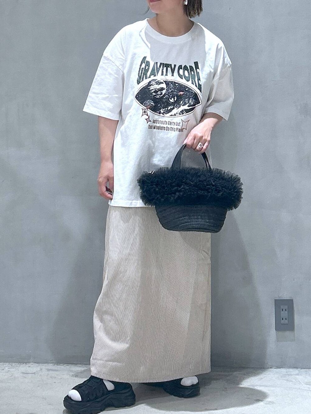 ブラック系のショルダーバッグ、ホワイト系のTシャツ/カットソー、ベージュ系のワンピースを着用したレディースの夏コーディネートの5枚目の写真