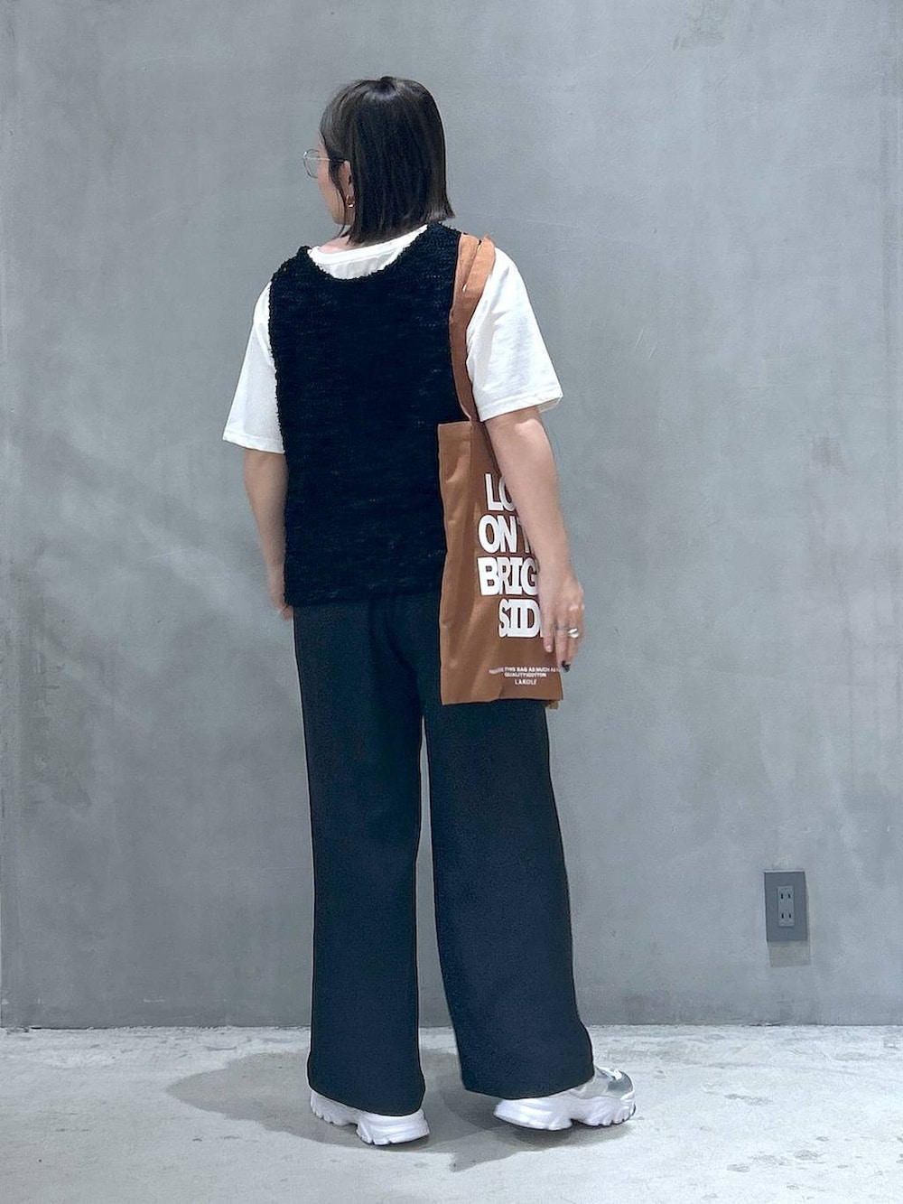 ブラック系のその他パンツ、シルバー系のスニーカー、ブラック系のベストを着用したレディースの春コーディネートの2枚目の写真