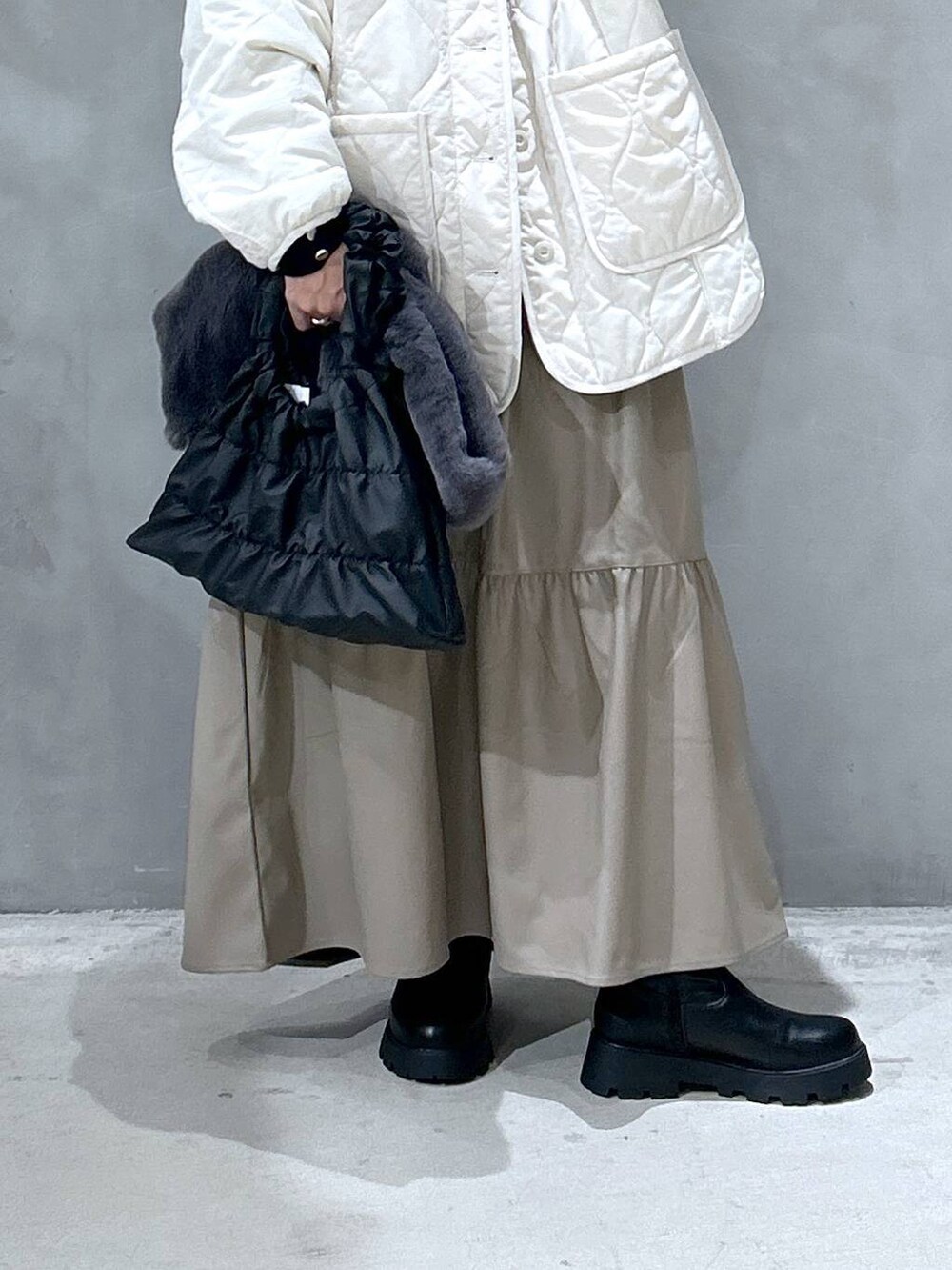 ブラック系のニット/セーター、ベージュ系のブルゾン、ブラック系のブーツを着用したレディースの秋コーディネートの4枚目の写真