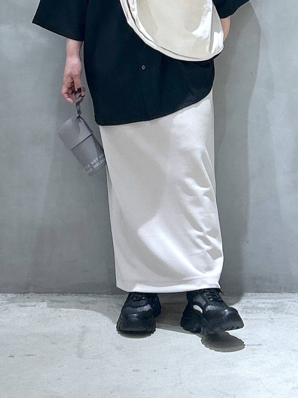 ベージュ系のショルダーバッグ、ブラック系のスニーカー、ベージュ系のスカートを着用したレディースの春コーディネートの5枚目の写真