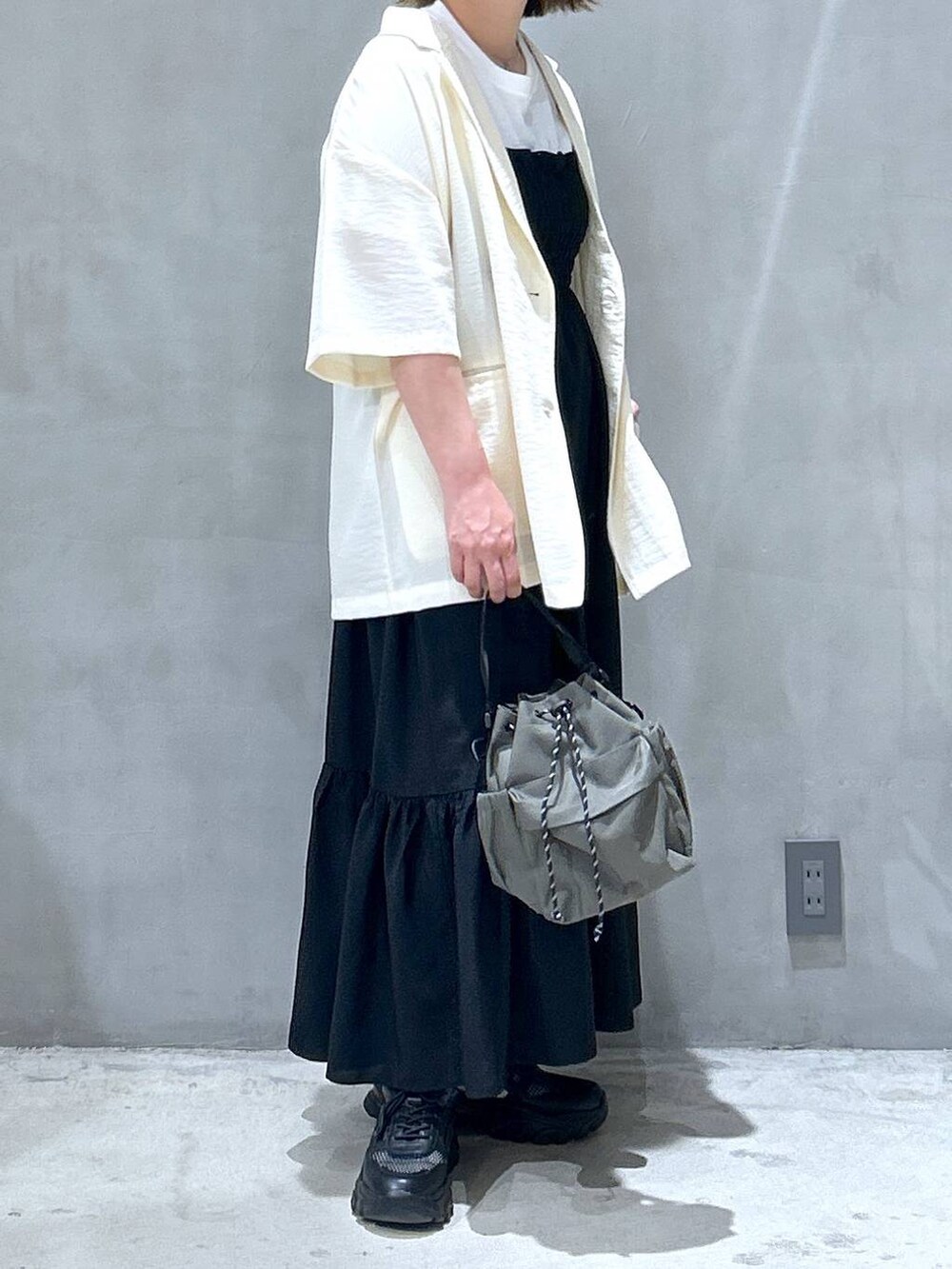 ブラック系のスニーカー、グリーン系のショルダーバッグ、ホワイト系のTシャツ/カットソーを着用したレディースの春コーディネートの5枚目の写真