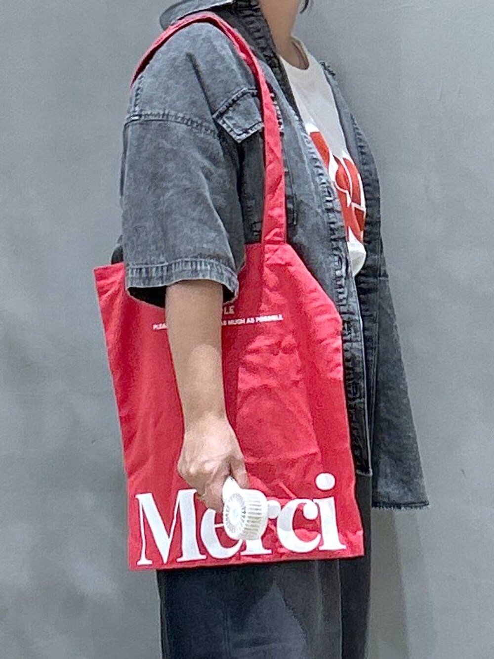 ブラック系のシャツ/ブラウス、レッド系のトートバッグ、ブラック系のデニムパンツを着用したレディースの夏コーディネートの6枚目の写真