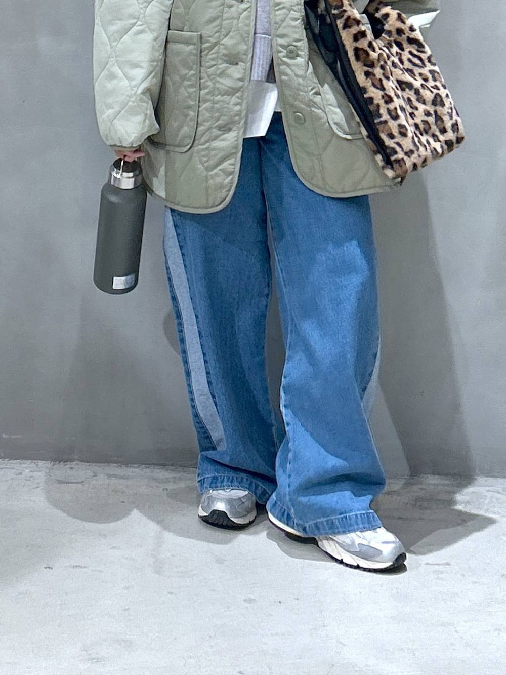 ブルー系のデニムパンツ、その他のショルダーバッグ、グリーン系のブルゾンを着用したレディースの秋コーディネートの4枚目の写真