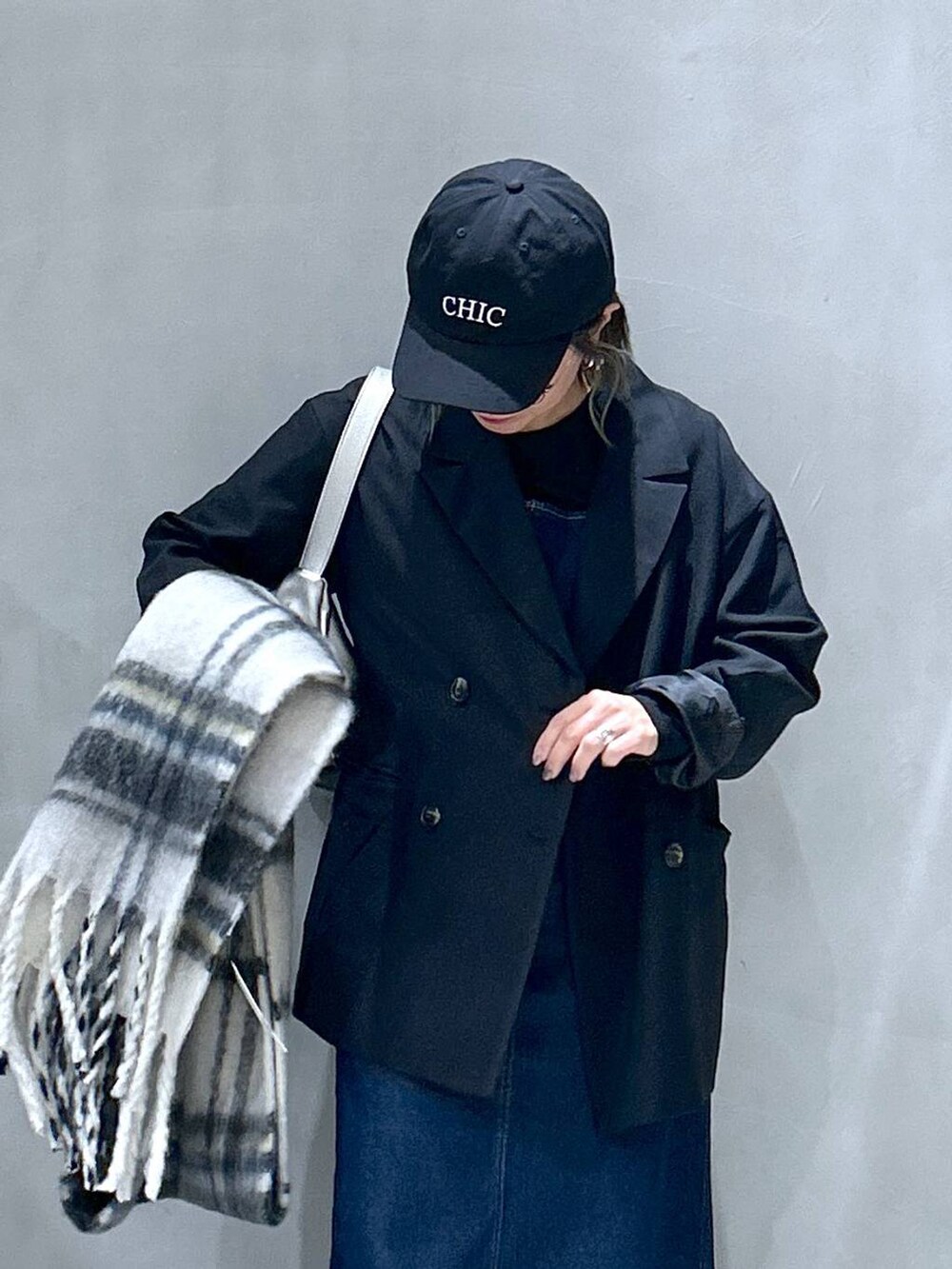 ブルー系のジャンパースカート、ブラック系のテーラードジャケット、その他のショルダーバッグを着用したレディースの秋コーディネートの3枚目の写真