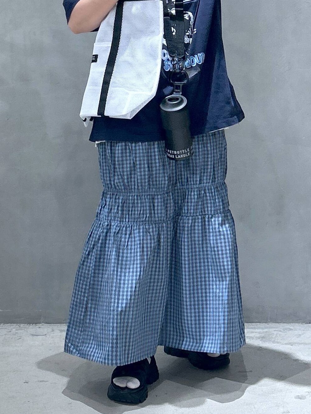 ブラック系のスニーカー、ホワイト系のTシャツ/カットソー、ブラック系のスマホグッズを着用したレディースの春コーディネートの4枚目の写真