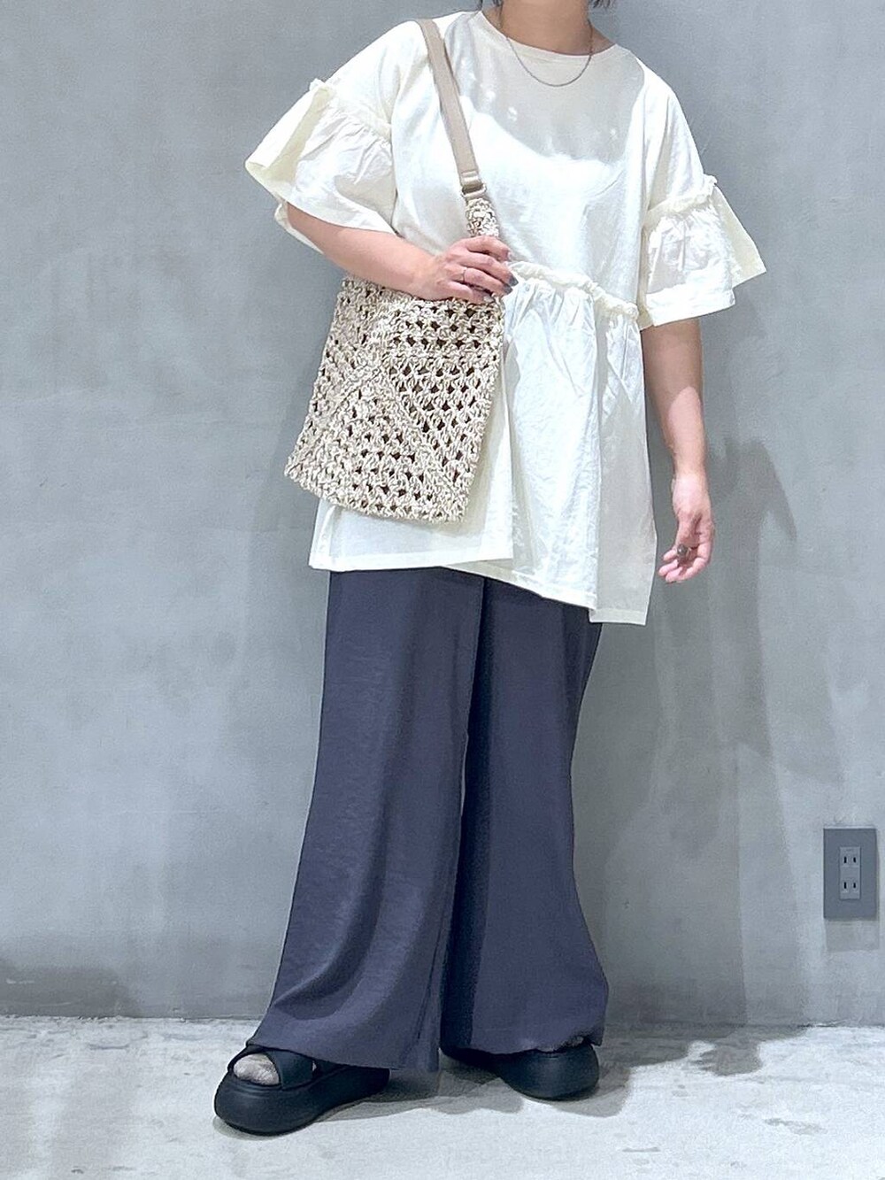 ベージュ系のトートバッグ、ブラック系のサンダル、グレー系のその他パンツを着用したレディースの夏コーディネートの5枚目の写真