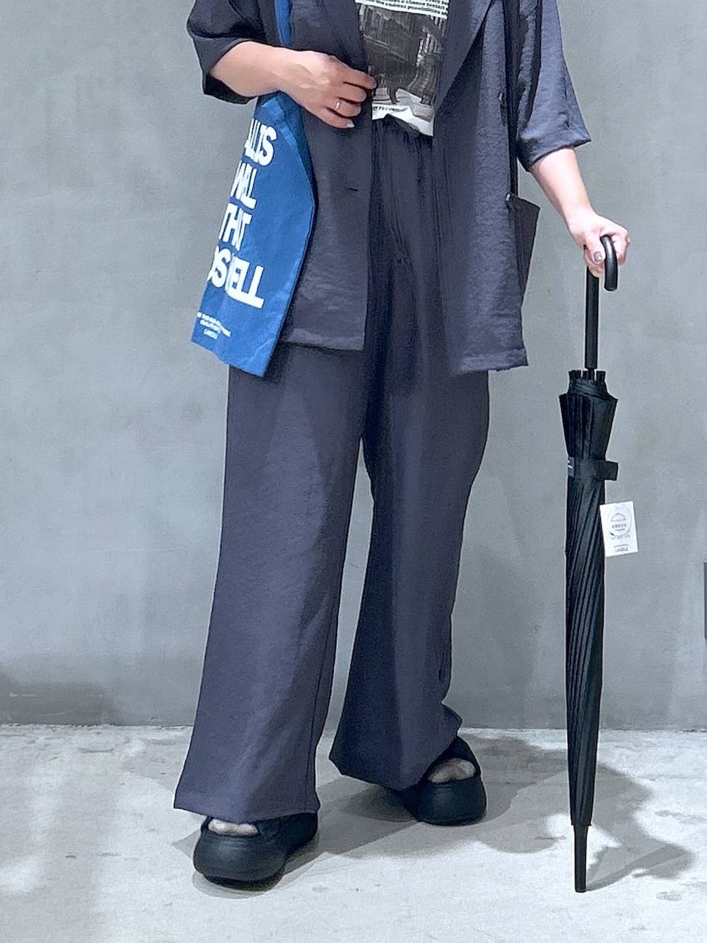 ブラック系のサンダル、ブルー系のトートバッグ、ベージュ系のテーラードジャケットを着用したレディースの夏コーディネートの6枚目の写真