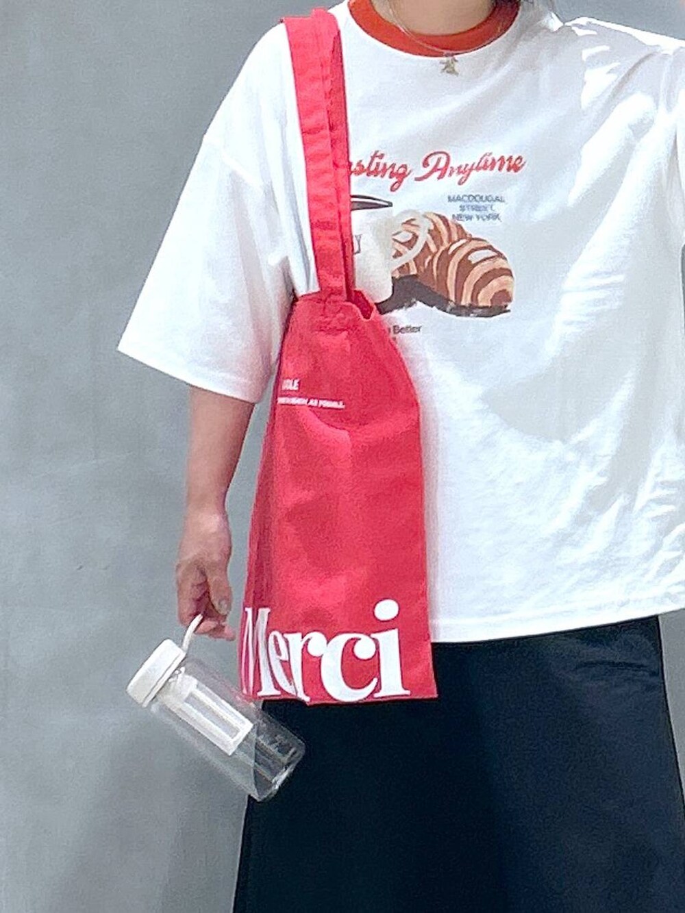 ブラック系のスニーカー、ブラック系のスカート、レッド系のTシャツ/カットソーを着用したレディースの春コーディネートの3枚目の写真