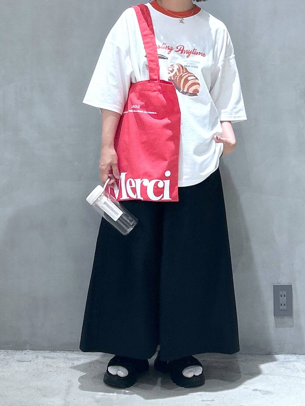 ブラック系のスニーカー、ブラック系のスカート、レッド系のTシャツ/カットソーを着用したレディースの春コーディネートの2枚目の写真