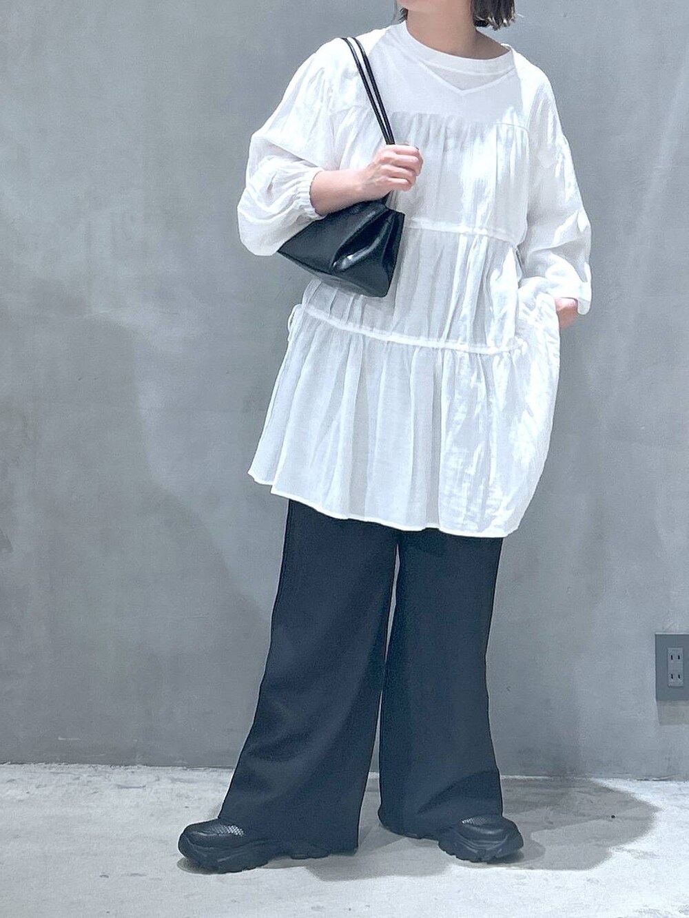 ブラック系のトートバッグ、ブラック系のスニーカー、ブラック系のその他パンツを着用したレディースの春コーディネートの2枚目の写真