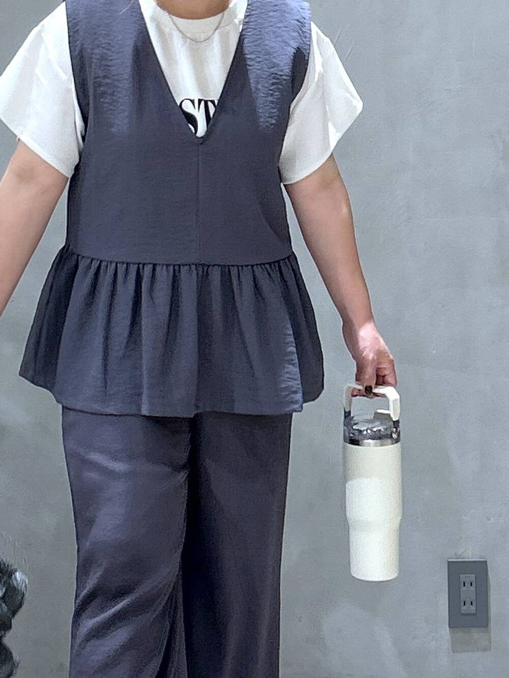 シルバー系のショルダーバッグ、ホワイト系のスニーカー、グレー系のその他パンツを着用したレディースの夏コーディネートの5枚目の写真