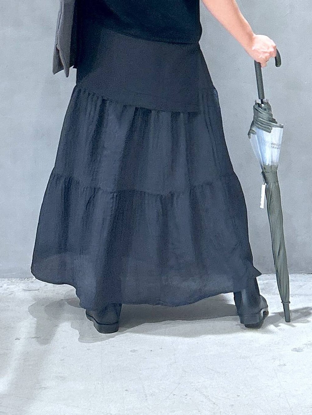 ブラック系のレインシューズ、ブラック系のTシャツ/カットソー、ブラック系のスカートを着用したレディースの夏コーディネートの5枚目の写真