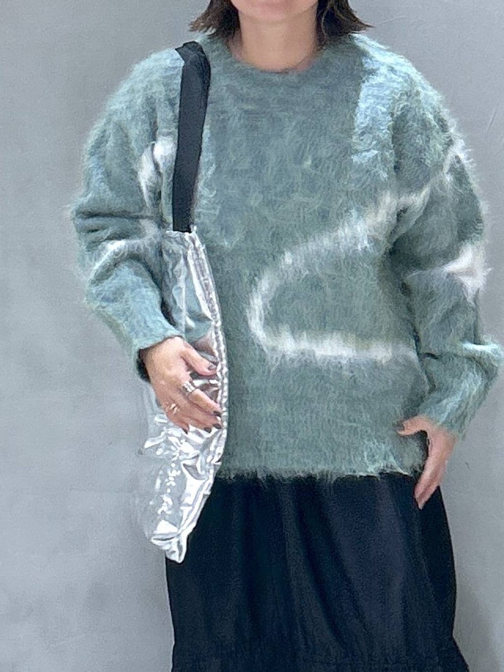 ホワイト系のスニーカー、グリーン系のニット/セーター、シルバー系のトートバッグを着用したレディースの秋コーディネートの2枚目の写真