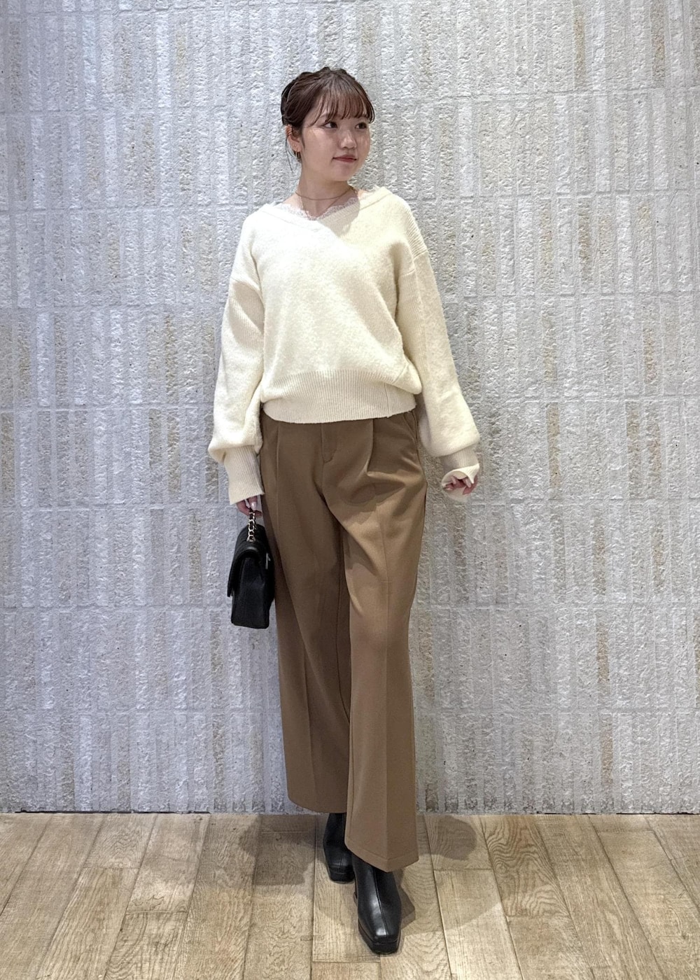 グレー系のブルゾン、ホワイト系のニット/セーター、イエロー系のその他パンツを着用したレディースの冬コーディネートの2枚目の写真