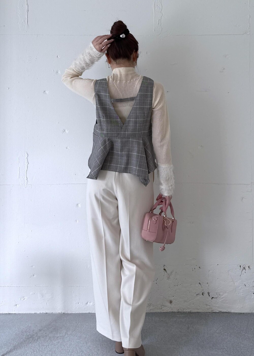 ホワイト系のスラックス、ピンク系のボストンバッグ、ベージュ系のブーツを着用したレディースの秋コーディネートの7枚目の写真