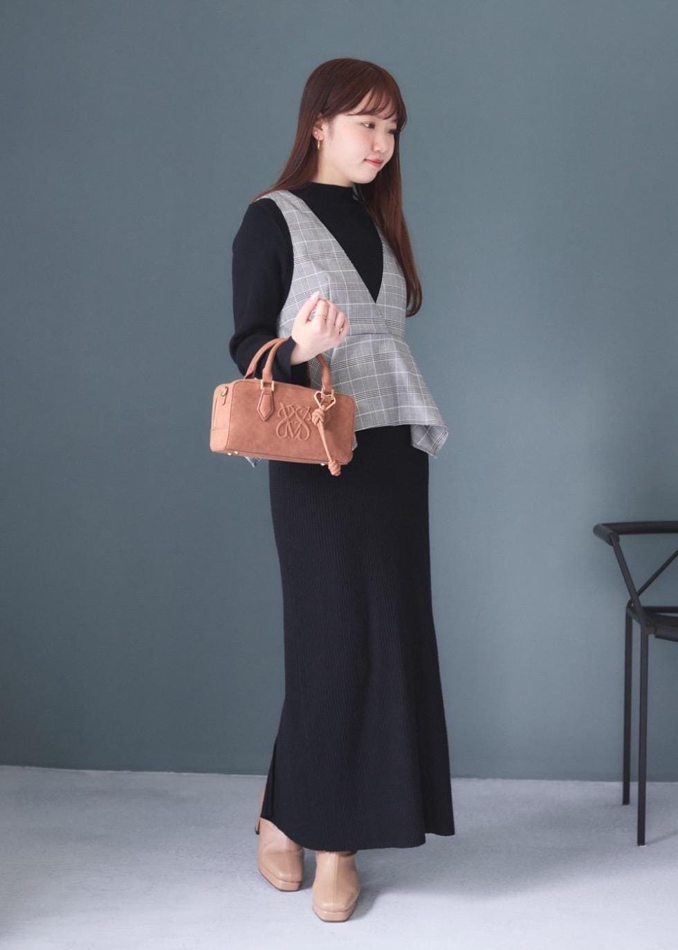 ホワイト系のキャミソール、ブラウン系のボストンバッグ、ベージュ系のブーツを着用したレディースの秋コーディネートの4枚目の写真